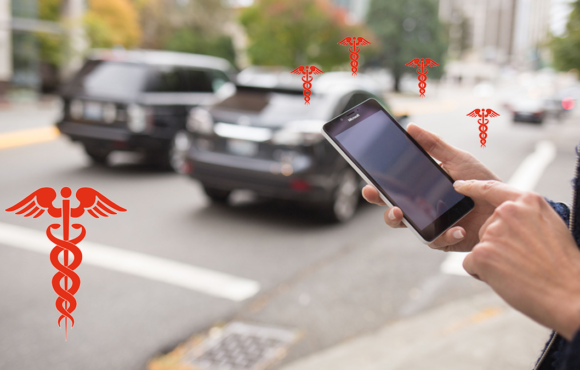 A person holding up their cell phone to take a picture of cars.