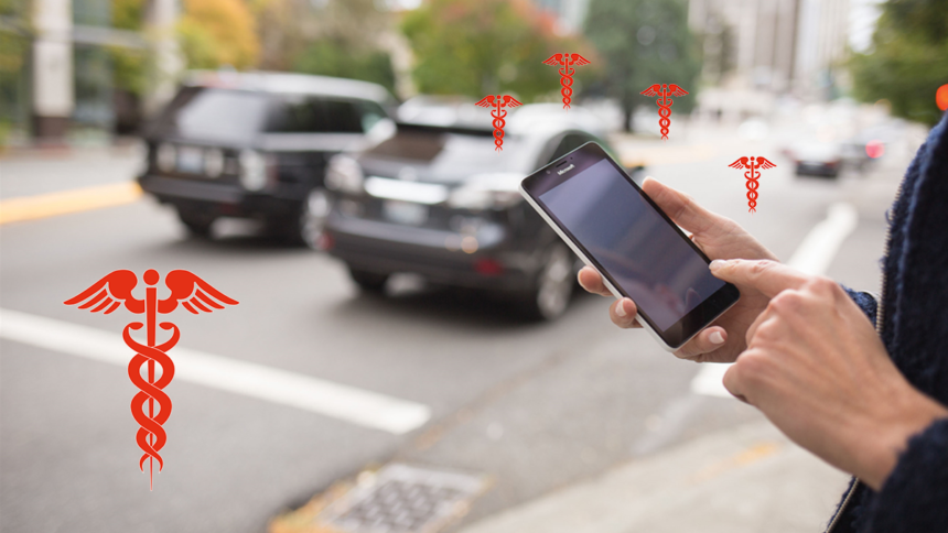 A person holding up their cell phone to take a picture of cars.