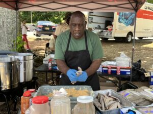 A man wearing an apron and gloves preparing food.