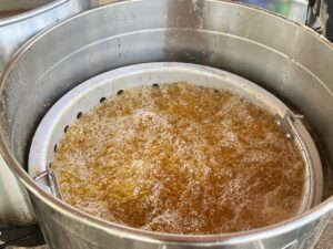 A large pot of brown liquid in a metal pan.