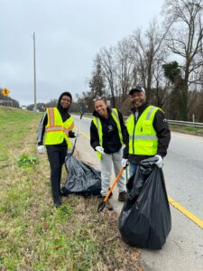 Three people standing on the side of a road.