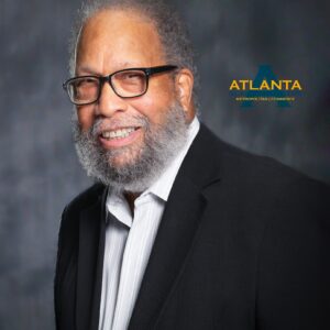 Smiling man in glasses and suit jacket.