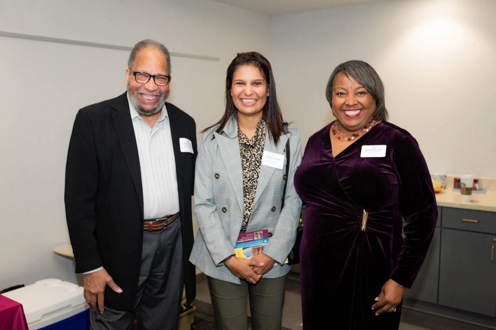 Three people standing next to each other in a room.