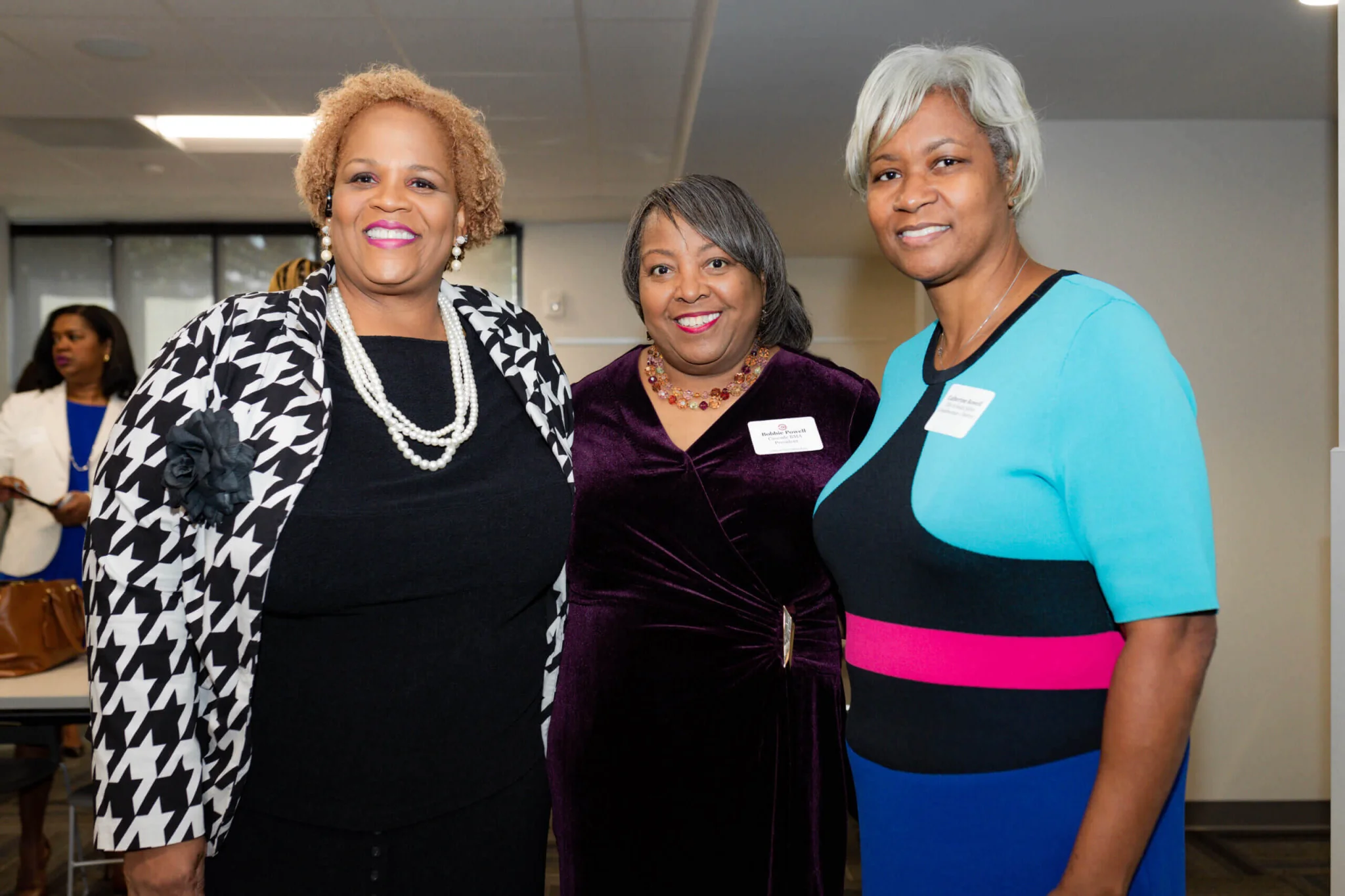 Three women standing next to each other in a room.