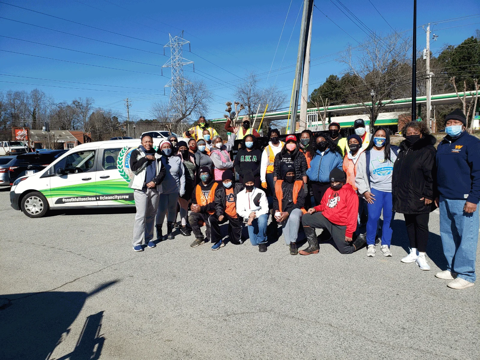 A group of people standing in front of a green and white van.